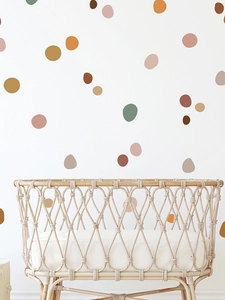 Detail of colorful irregular dot wall decals in Morandi tones on a white wall above a crib