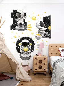 Close-up of cartoon astronaut wall stickers featuring rockets and stars in a kids room
