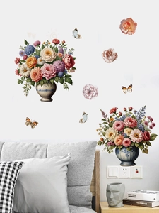 Detail of floral butterfly PVC wall stickers on bedroom wall above grey headboard
