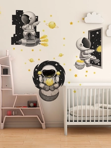 Detail of cartoon astronaut wall stickers featuring rockets and stars in a nursery room