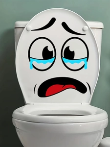 Close-up of a funny crying face waterproof PVC sticker on a white ceramic toilet lid