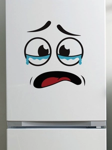 Close-up of a funny crying face cartoon sticker on a white surface for home decor