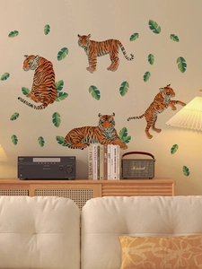 Detail of tiger wall stickers with tropical leaves displayed on a living room wall