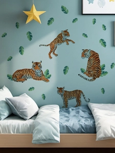 Detailed close-up of realistic tiger wall stickers and tropical green leaves on a blue wall
