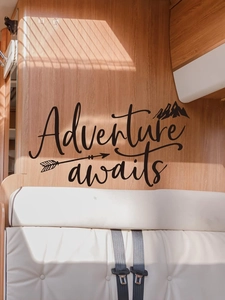 Adventure awaits wall decal featuring mountains and arrows on a camper wood wall
