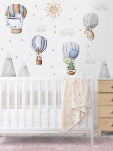 Detail of dinosaur hot air balloon wall decals in a modern nursery with soft colors