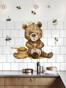 Detail of cartoon bear and honey bees wall decals on kitchen tiles with props