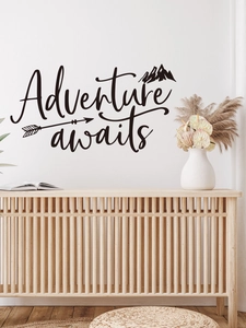 Detail of Adventure awaits mountain wall sticker above a wooden cabinet in a living room