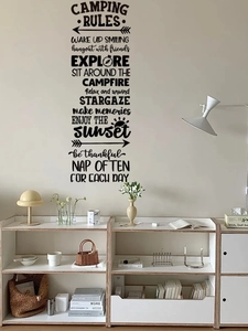 Close-up of black PVC Camping Rules wall sticker with forest symbols on a light wall