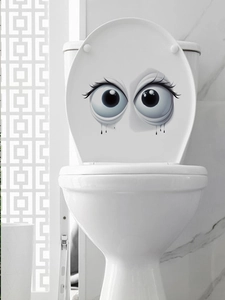 Detailansicht lustiger Toilettenaufkleber mit großen Augen und Wimpern im Badezimmer