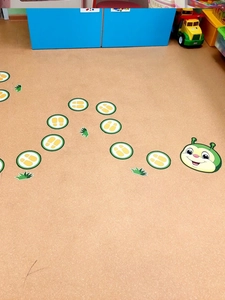 Macro detail of cartoon caterpillar floor decals and footprint path for playroom