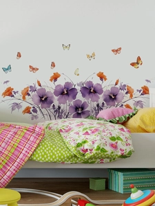 Detail of purple floral wall stickers and colorful butterflies in a cozy bedroom scene