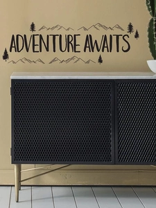 Close-up of Adventure Awaits wall sticker with mountain and forest silhouette over a side cabinet
