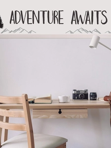 Detail of Adventure Awaits wall decal with mountain art above a wooden desk