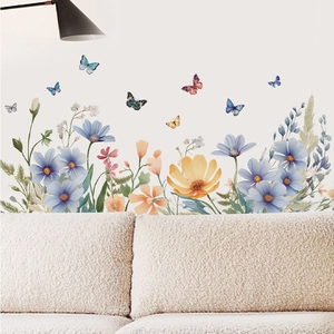 Floral and butterfly wall stickers in watercolor style over a modern sofa in a living room