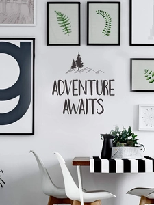 Detail of Adventure Awaits wall decal featuring mountain and forest icons in black PVC