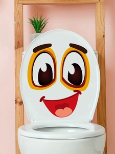 Macro detail of cartoon smiley face decal on a white toilet lid for bathroom decor