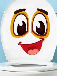 Detail of cute cartoon smiling face sticker on white toilet lid for bathroom decor