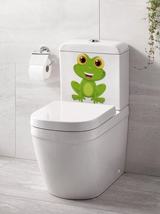Close-up of a cute green cartoon frog waterproof PVC sticker on a white toilet tank surface