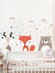 Nursery scene showing cartoon fox and bear wall decals above a crib in warm tones