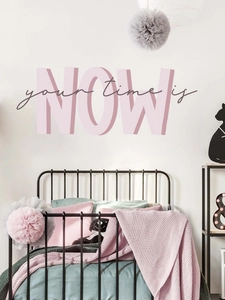 Dettaglio dell'adesivo murale 3D rosa 'your time is NOW' su parete bianca in camera da letto