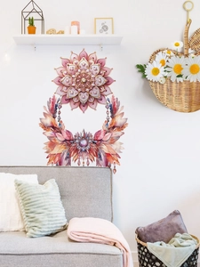 Dettaglio dell'adesivo murale mandala rosa con nappe di piume su una parete bianca