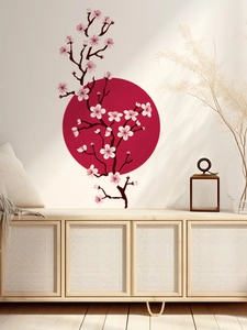 Detail of pink cherry blossom wall stickers with a red sun motif on a white wall