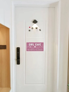 Détail de la plaque de porte rose Girl Cave avec texte No Boys Allowed sur porte blanche