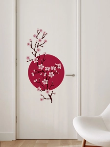 Detailed view of pink cherry blossom and red sun wall stickers on a white interior door