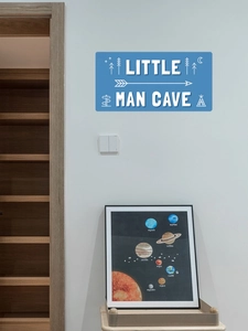 Sticker Little Man Cave sur mur blanc avec bibliothèque et affiche du système solaire