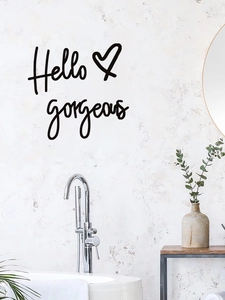 Detail view of Hello Gorgeous wall decal in bathroom setting with eucalyptus decor
