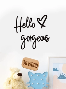 Detailed view of black 3D wood Hello Gorgeous wall decal in a cozy bedroom setting