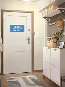 Sticker mural bleu Little Man Cave sur une porte blanche dans une entrée de maison chic