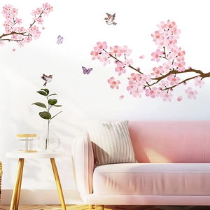 Détail de stickers muraux fleurs de cerisier roses avec oiseaux sur un mur de salon blanc