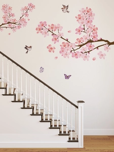 Détail de stickers muraux fleurs de cerisier avec pétales roses et oiseaux sur un escalier