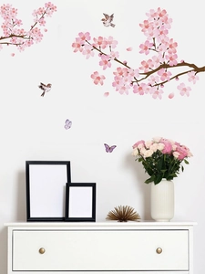 Détail de stickers muraux fleurs de cerisier roses avec oiseaux et papillons sur mur blanc