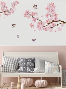 Gros plan d'autocollants muraux cerisier rose avec moineaux et papillons sur un mur blanc