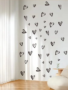 Detail of hand-drawn black heart wall stickers on white surface for modern living room decor