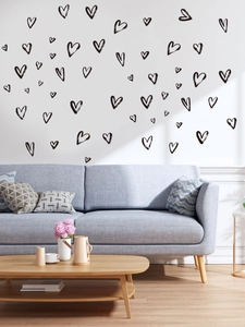 Detail of hand-drawn heart wall stickers in a modern living room setting with sofa