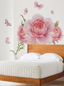 Détail de stickers muraux roses aquarelles et papillons dans une chambre à coucher chaleureuse