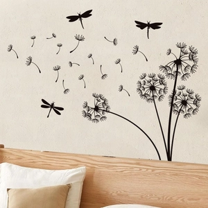 Close-up of black dandelion and dragonfly wall stickers on a bedroom wall surface