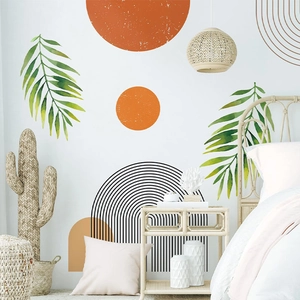 Boho wall decal featuring orange sun and tropical green leaves in a cozy bedroom setting