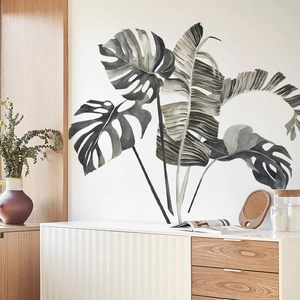 Detail of tropical monstera wall decals in watercolor style on a minimalist white wall