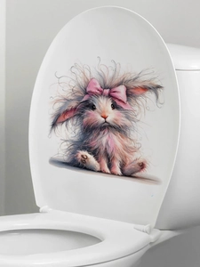Close-up of a furry Easter bunny sticker with pink bow applied on a white toilet lid