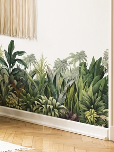 Detailed view of tropical palm and banana leaf wall decals on a white home wall