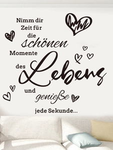 Detail of inspirational German quote wall decal with hearts on white wall in a cozy living room