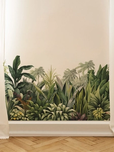 Detailed close-up of tropical palm and banana leaf wall decals on a living room wall