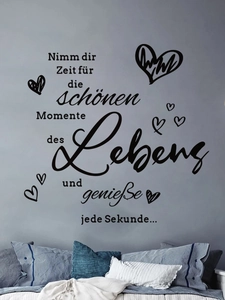Close-up of German inspirational wall decal with heart motifs on bedroom wall surface