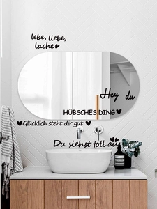 Detail of German inspirational quotes wall stickers on a modern white tiled bathroom wall