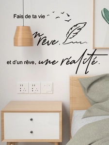 Detail of French quote wall decal with feathers and birds on a modern bedroom wall